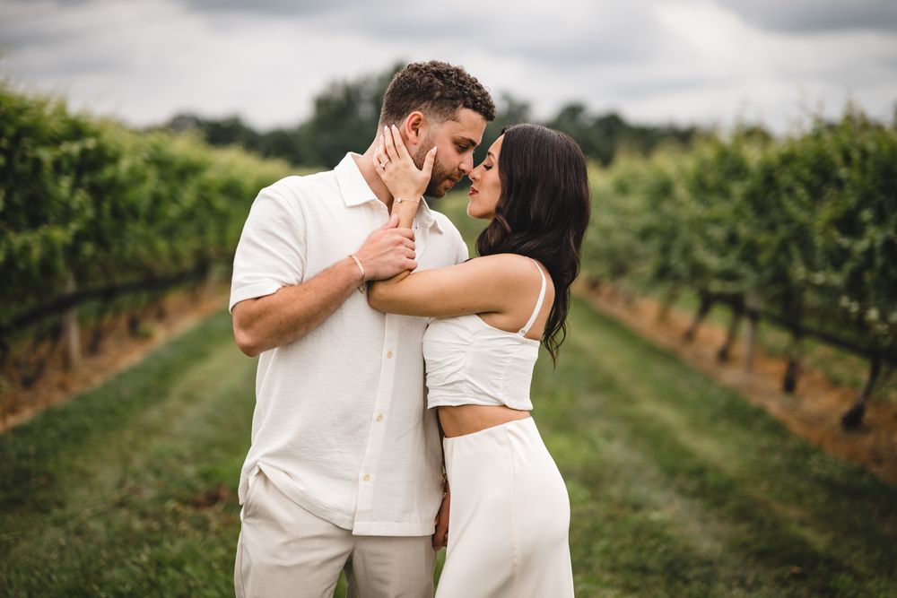 A couple sharing emotional moments in a lush vineyard setting.