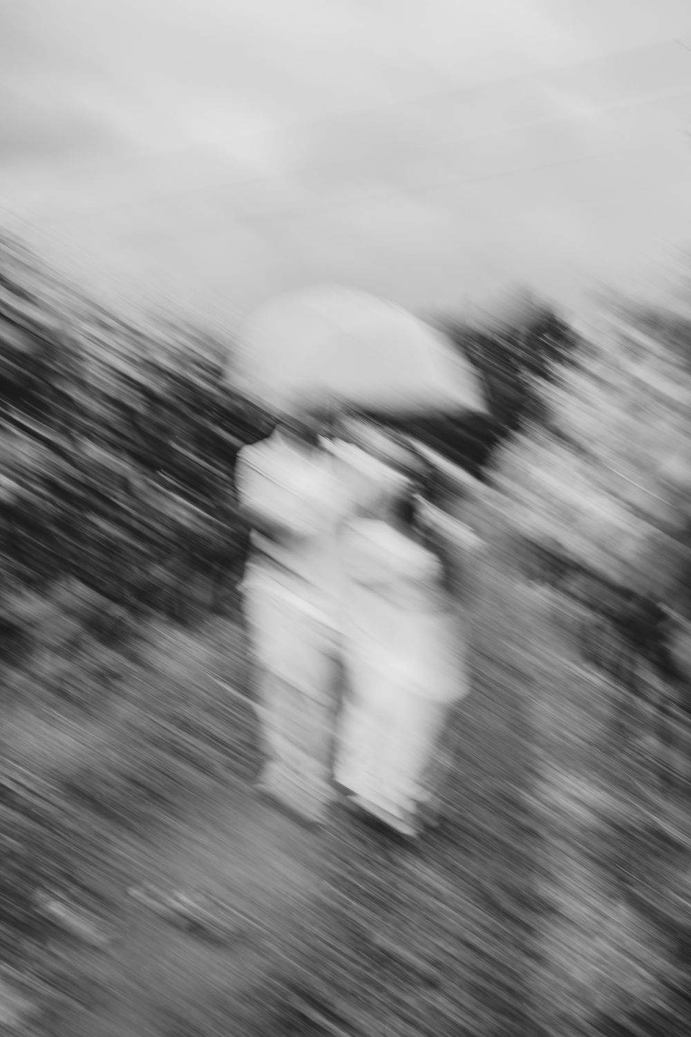 Abstract motion blur of figures in white against a dark background.