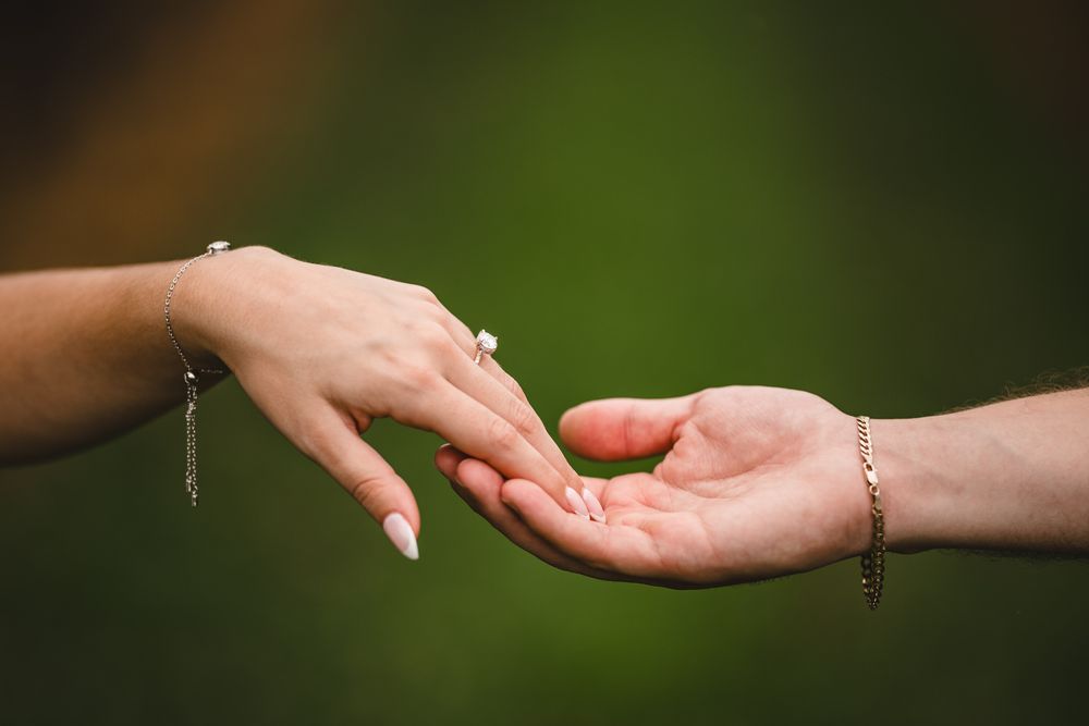 Series of hands reaching towards each other against blurred green background.