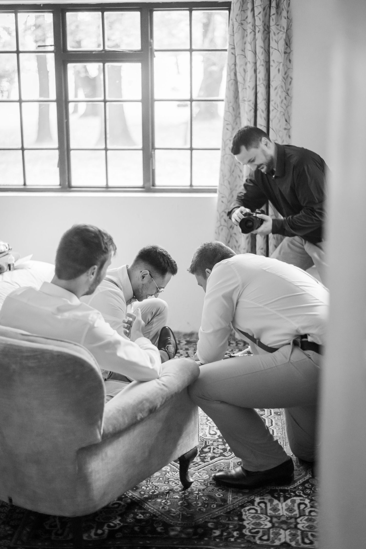 Five black and white photographs show people sitting side by side and leaning forward with vintage cameras in their hands.