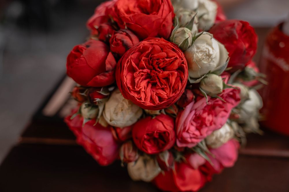 Vibrant red garden roses mixed with white blooms create a romantic wedding bouquet.
