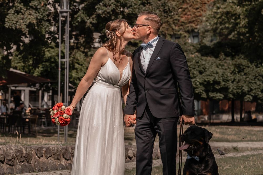 A bride and groom share a tender moment in an outdoor autumn setting surrounded by fall foliage.