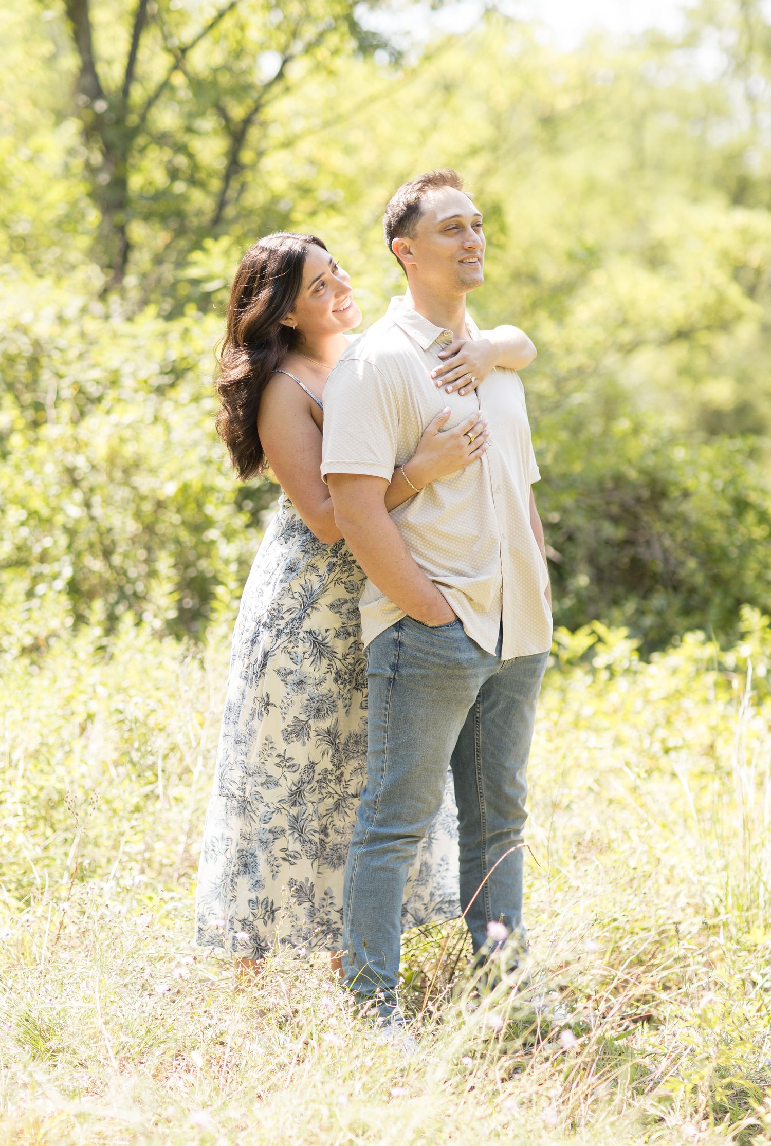 A romantic couple embraces in a sun-drenched meadow filled with golden wildflowers and soft natural light.