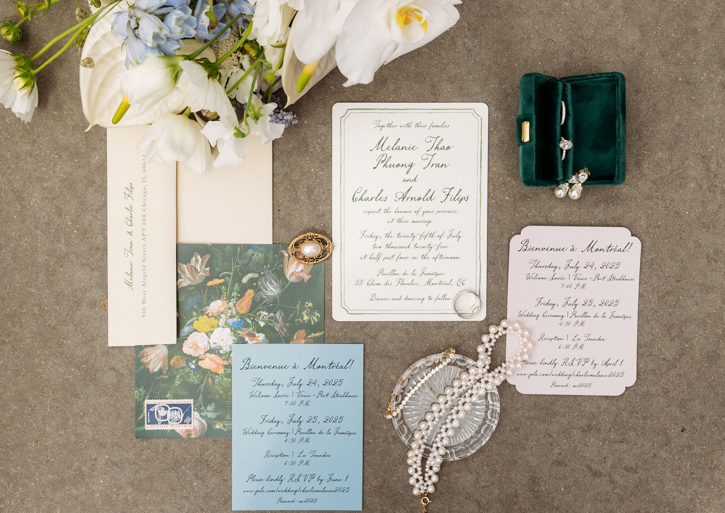 Elegant wedding invitation suite with white flowers, vintage stamps, and delicate lace details on a gray linen background.