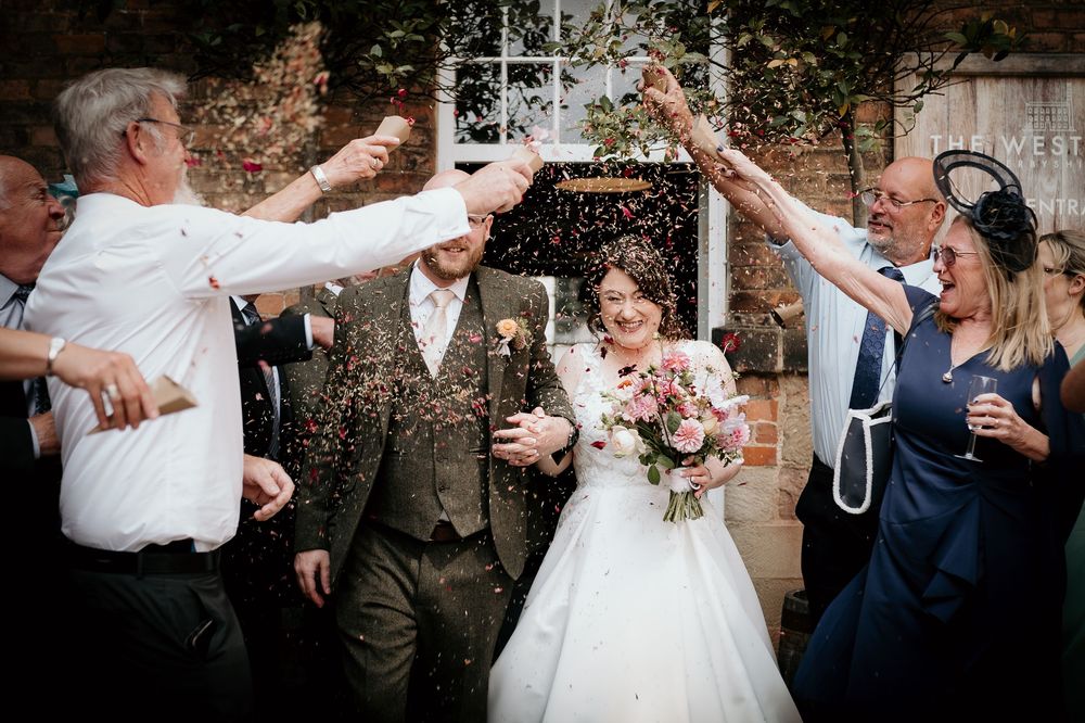 Wedding guests celebrate with confetti and champagne during an outdoor reception celebration.