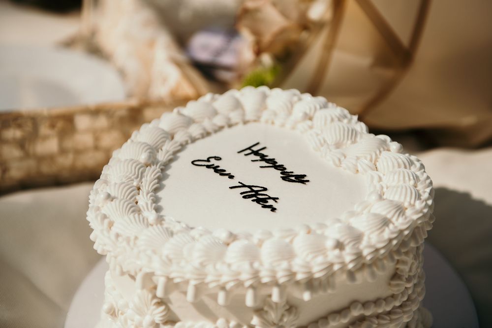 Classic white wedding cake decorated with elegant pearl-like frosting details.