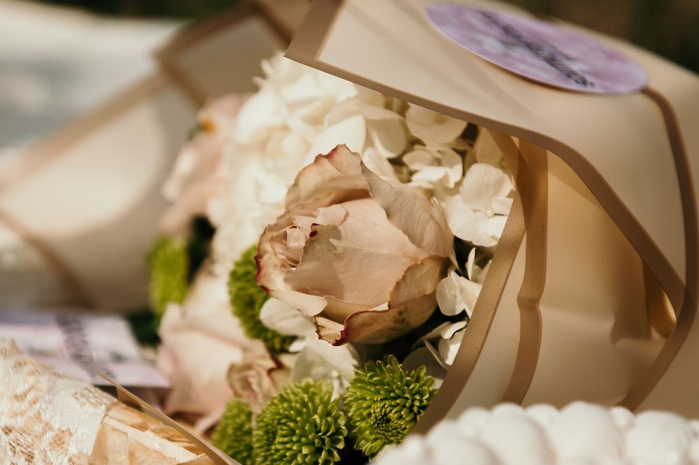 Delicate floral centerpiece with soft pink roses and white flowers.
