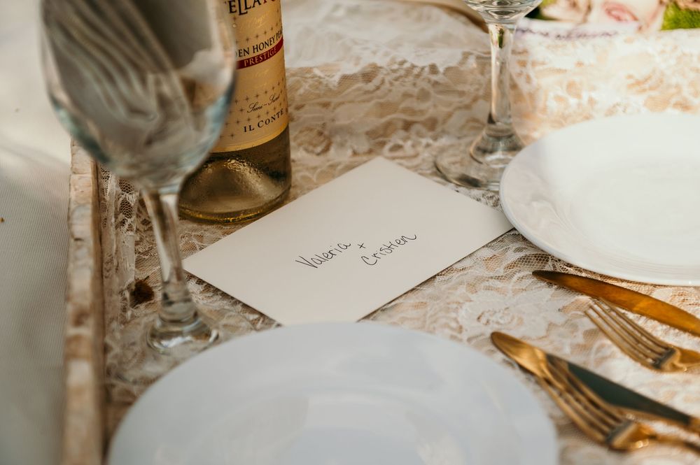 Elegant table setting with lace tablecloth and fine dining utensils.