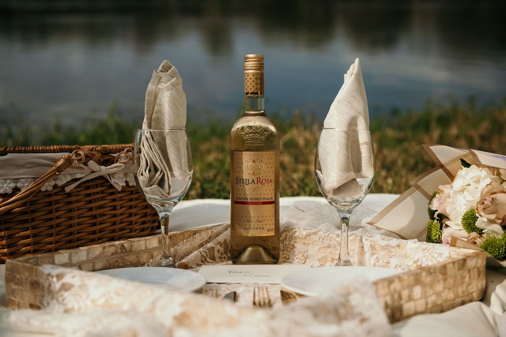 Elegant table setting with wine bottles and glassware on textured natural fabric.