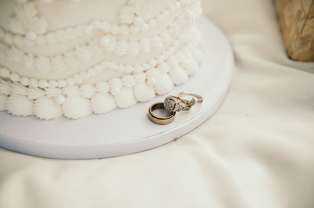 Wedding rings displayed on a white lace surface with delicate scalloped details around the edges.