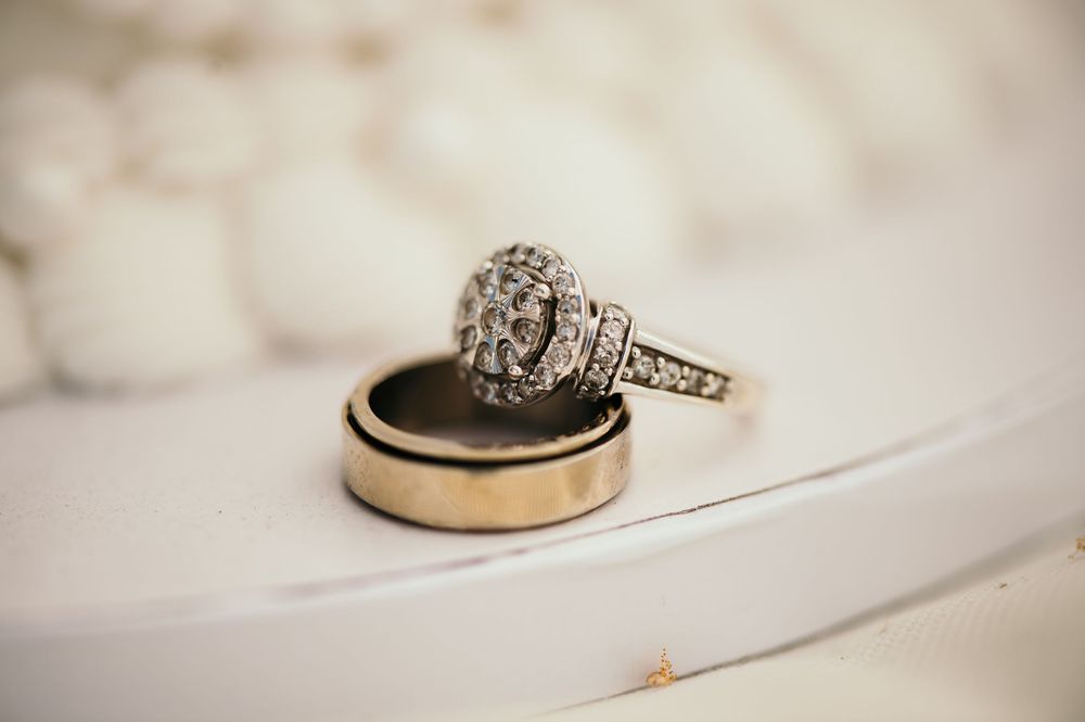 Close-up shots of wedding rings and engagement rings displayed on a textured white surface in a collage format.