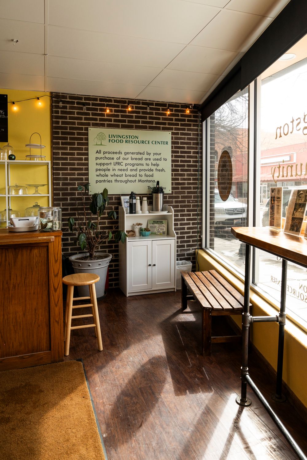 Interior view of a rustic restaurant space with wooden floors and brick walls.