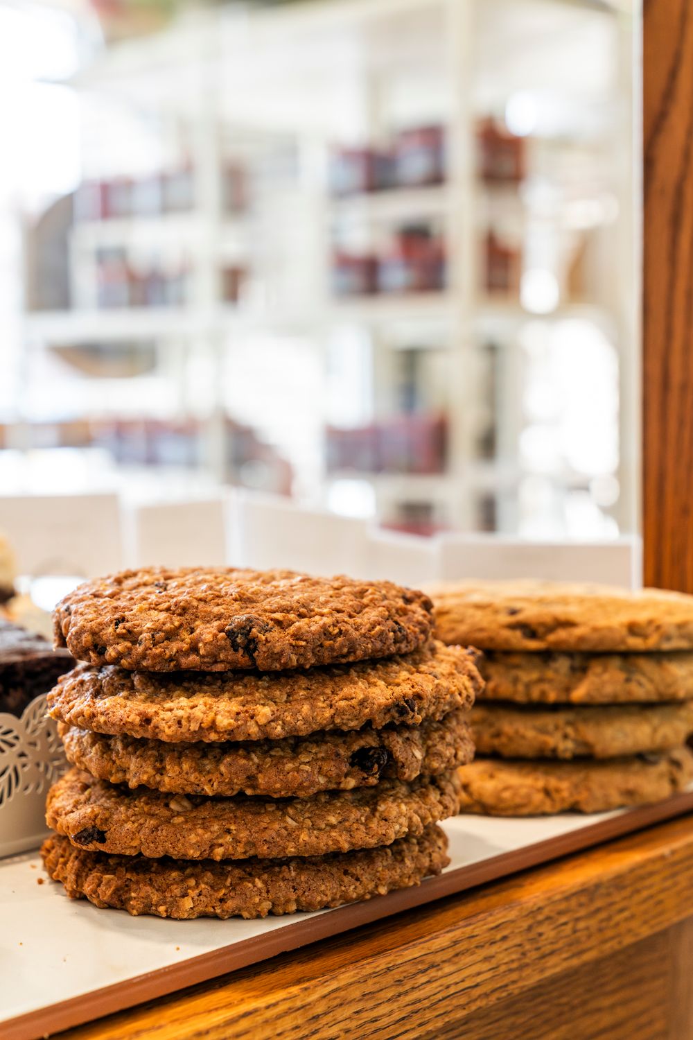 Stack of freshly baked oatmeal cookies displayed on wooden surface.