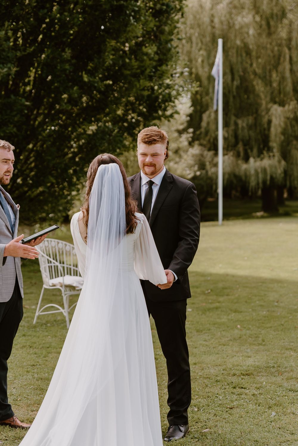 A couple shares their first look moment during an outdoor garden wedding ceremony.