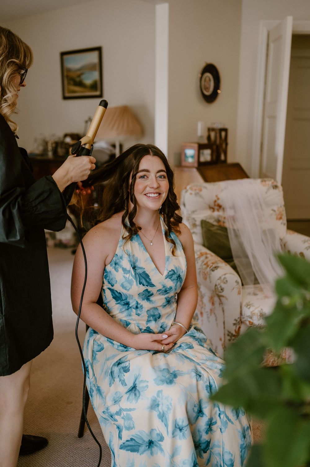 A person wearing a blue and white floral dress sits comfortably in an elegantly decorated room.
