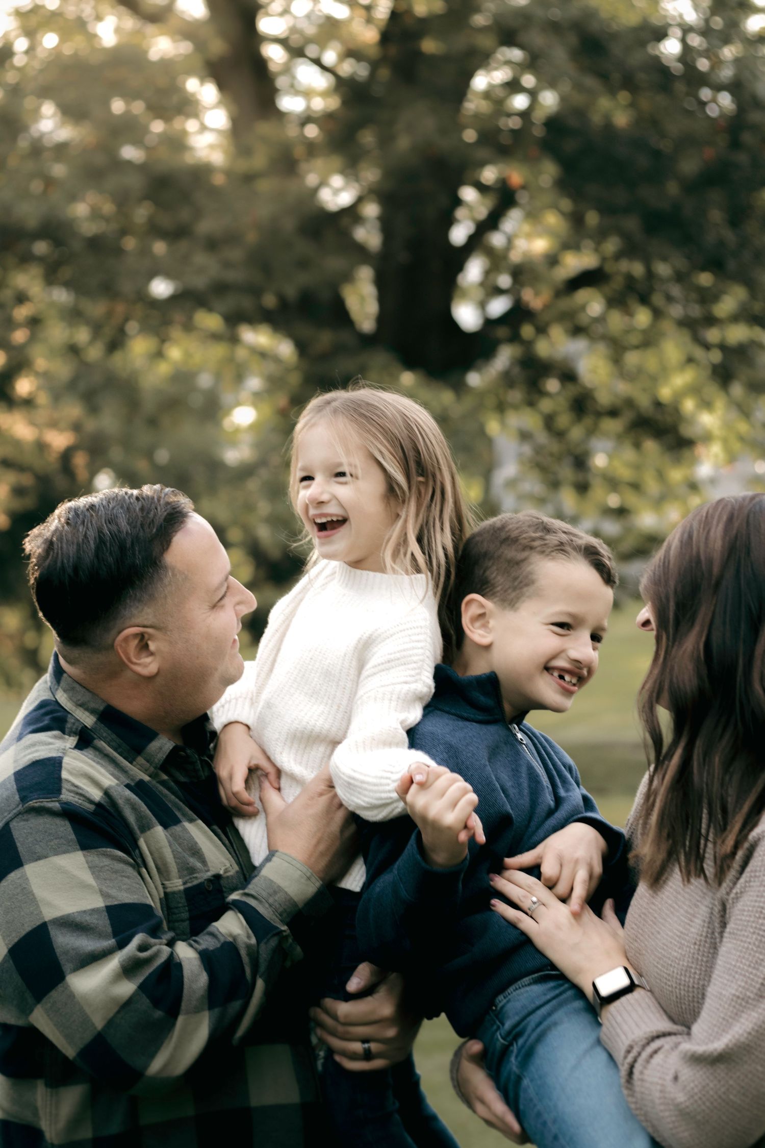 A series of outdoor candid family photos showing laughter and joyful interactions against a blurred natural background.