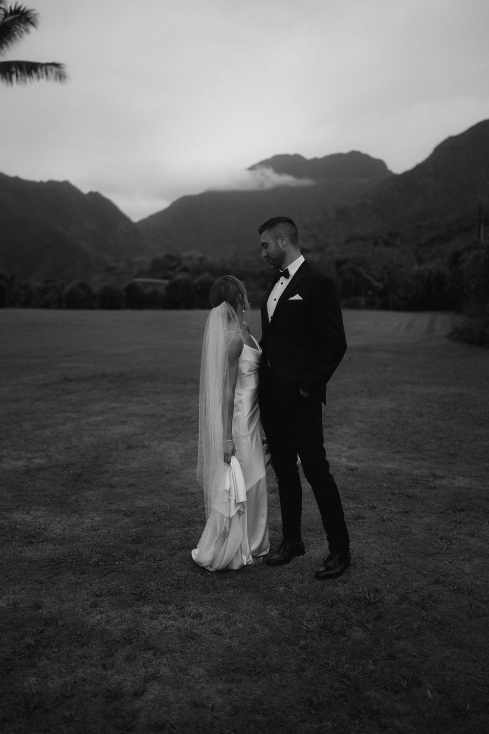 Bride and groom walking amongst the palm trees in Hanalei Bay