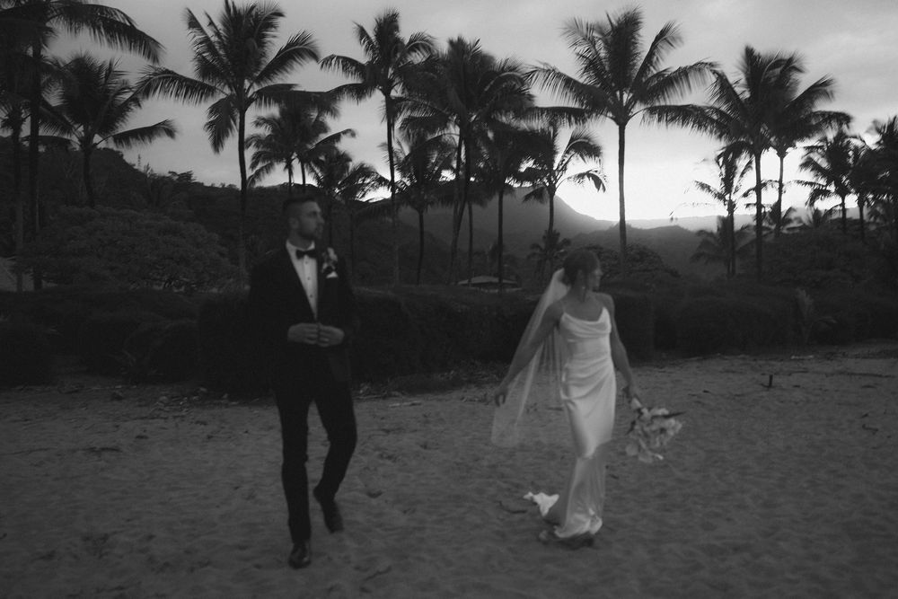 Bride and groom walking amongst the palm trees in Hanalei Bay