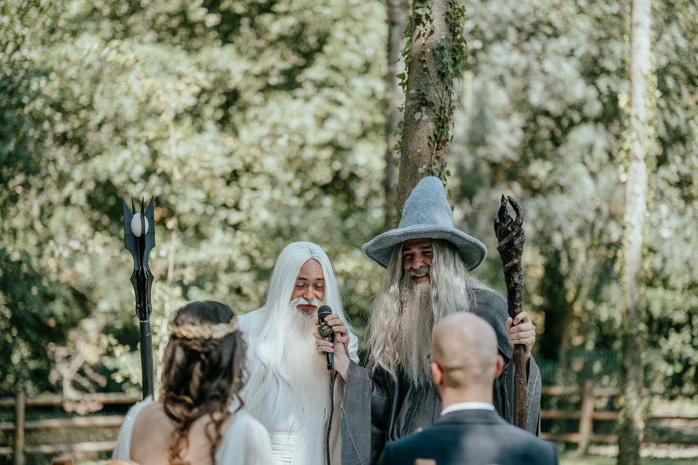 Lord of the Rings themed wedding ceremony with Gandalf and Saruman officiants in an outdoor forest setting.