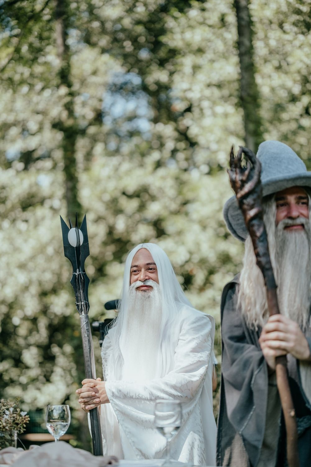 Two men cosplaying as Gandalf and Saruman from Lord of the Rings at an outdoor event.