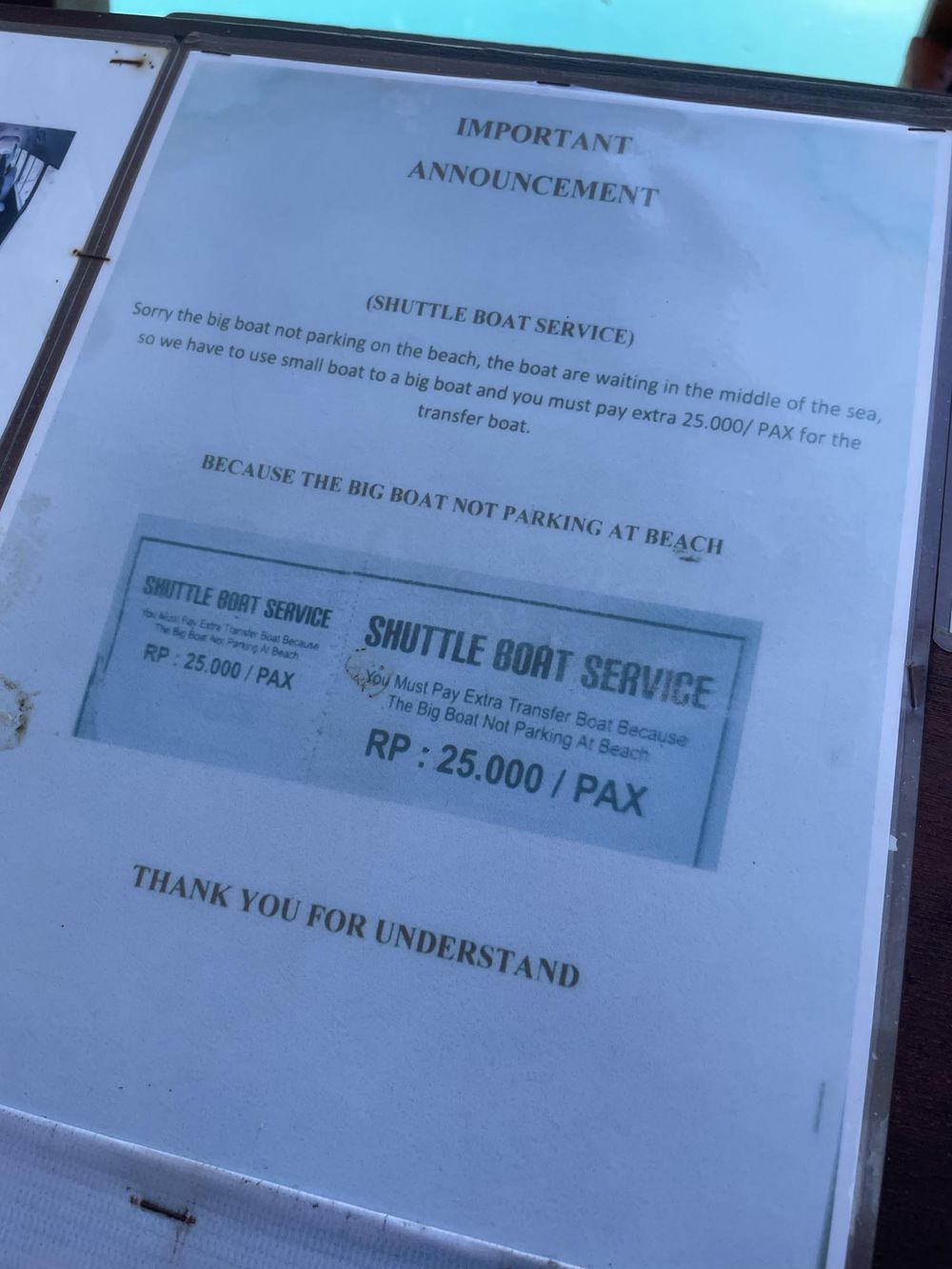 Important announcement sign for shuttle boat service charging RP 25,000 per passenger for transfer boats in Indonesia.