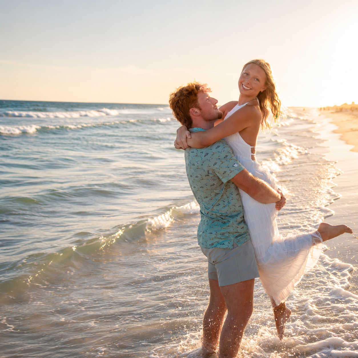 Young couple shares a tender forehead kiss on beach at pastel sunset.