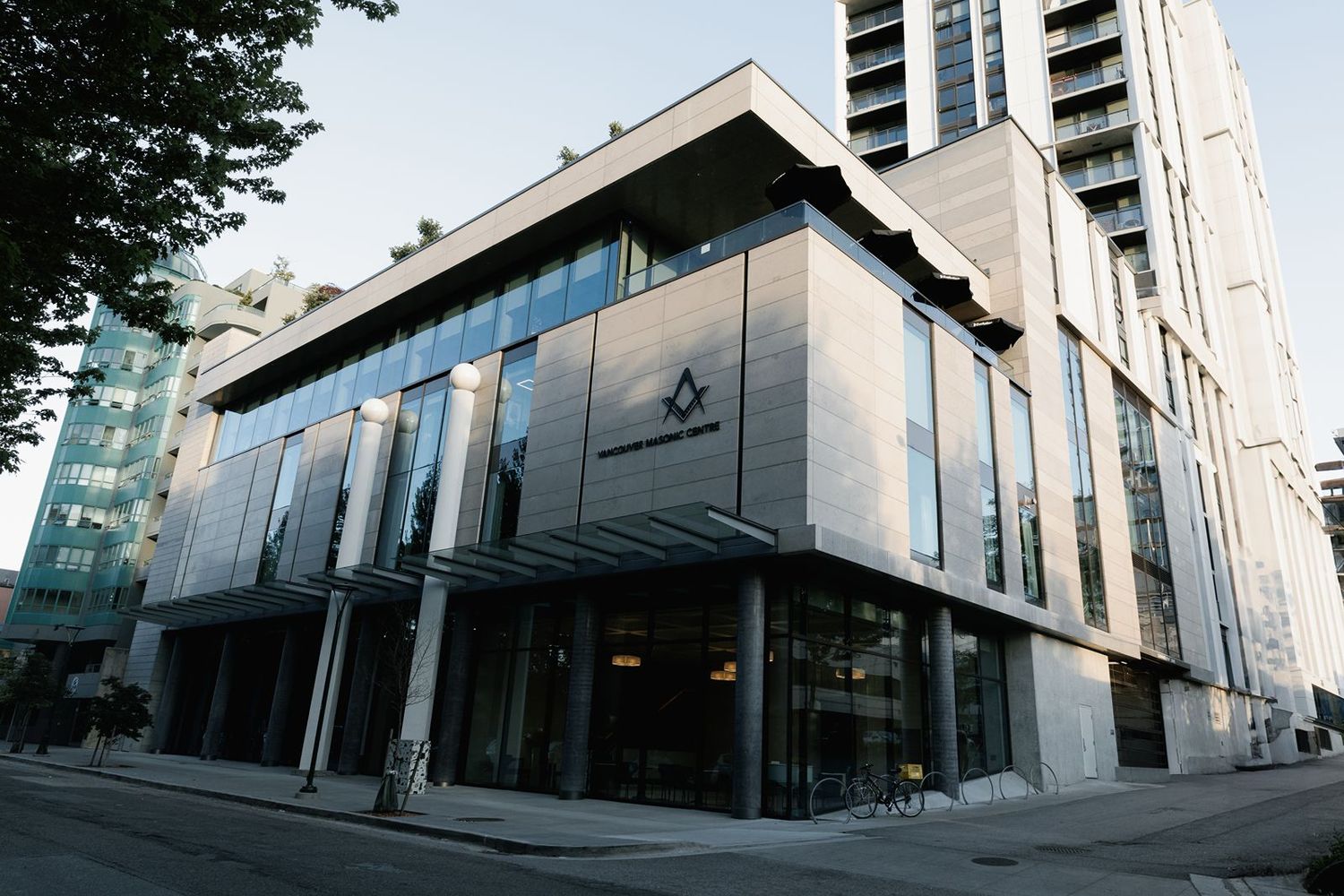 Contemporary Freemasons Hall building with glass exterior and Masonic emblem in an urban downtown setting.