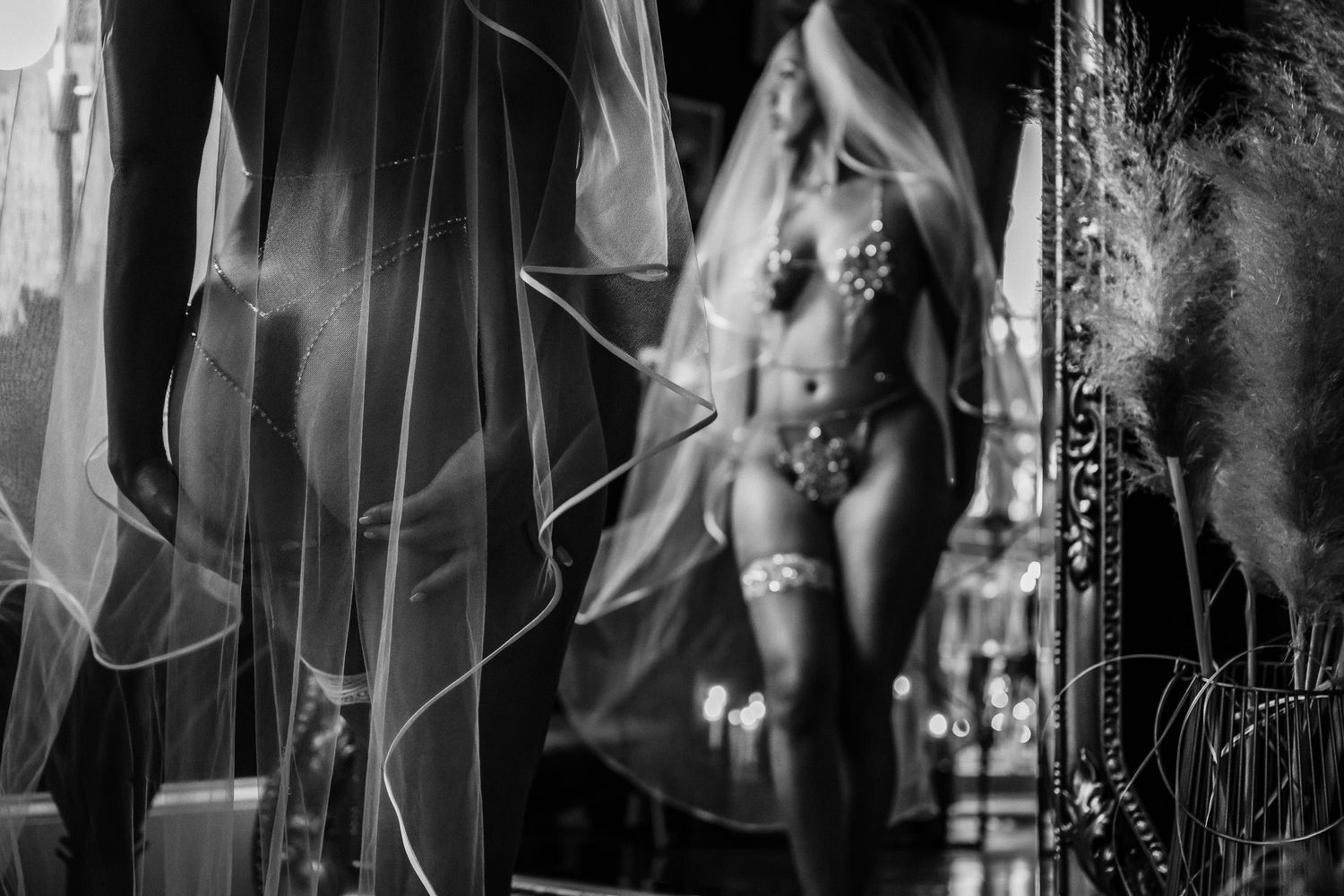 Bridal boudoir photography New Orleans - black and white boudoir photo of a woman in lingerie reflected in an ornate mirror with sheer veil.