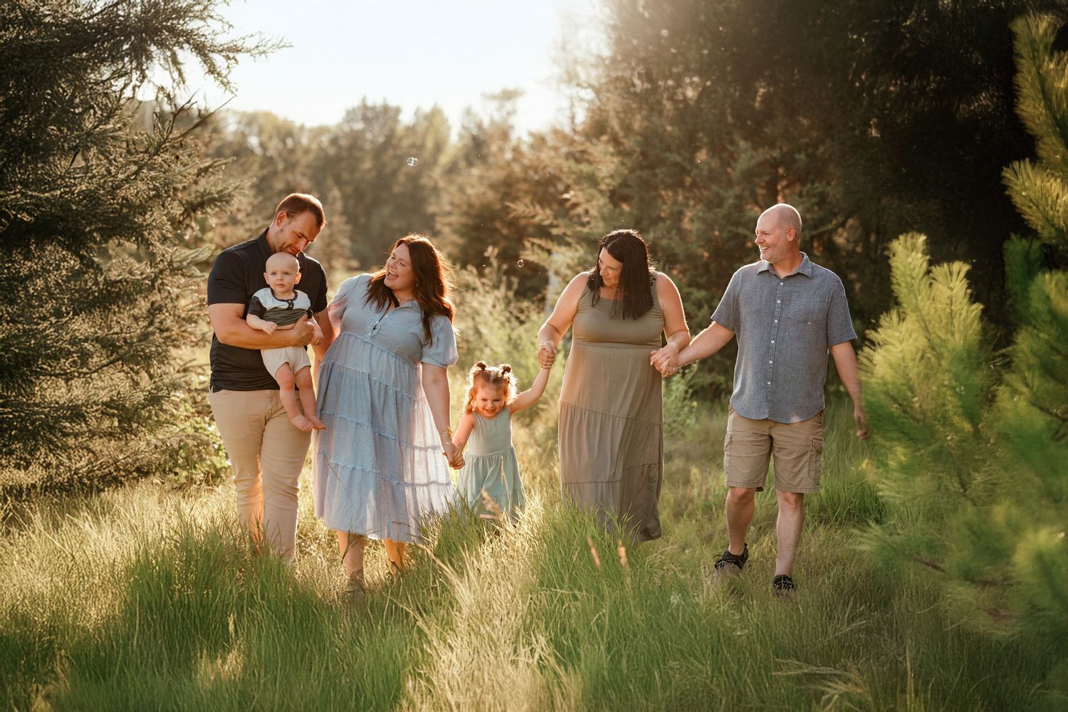 Brookings South Dakota family photos featuring parents and children smiling together in a natural green setting.