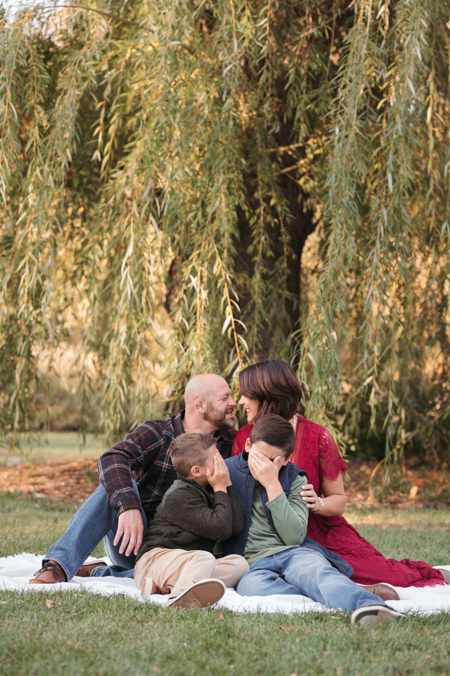 Family portrait in a peaceful outdoor setting with soft green tones in Brookings, South Dakota.