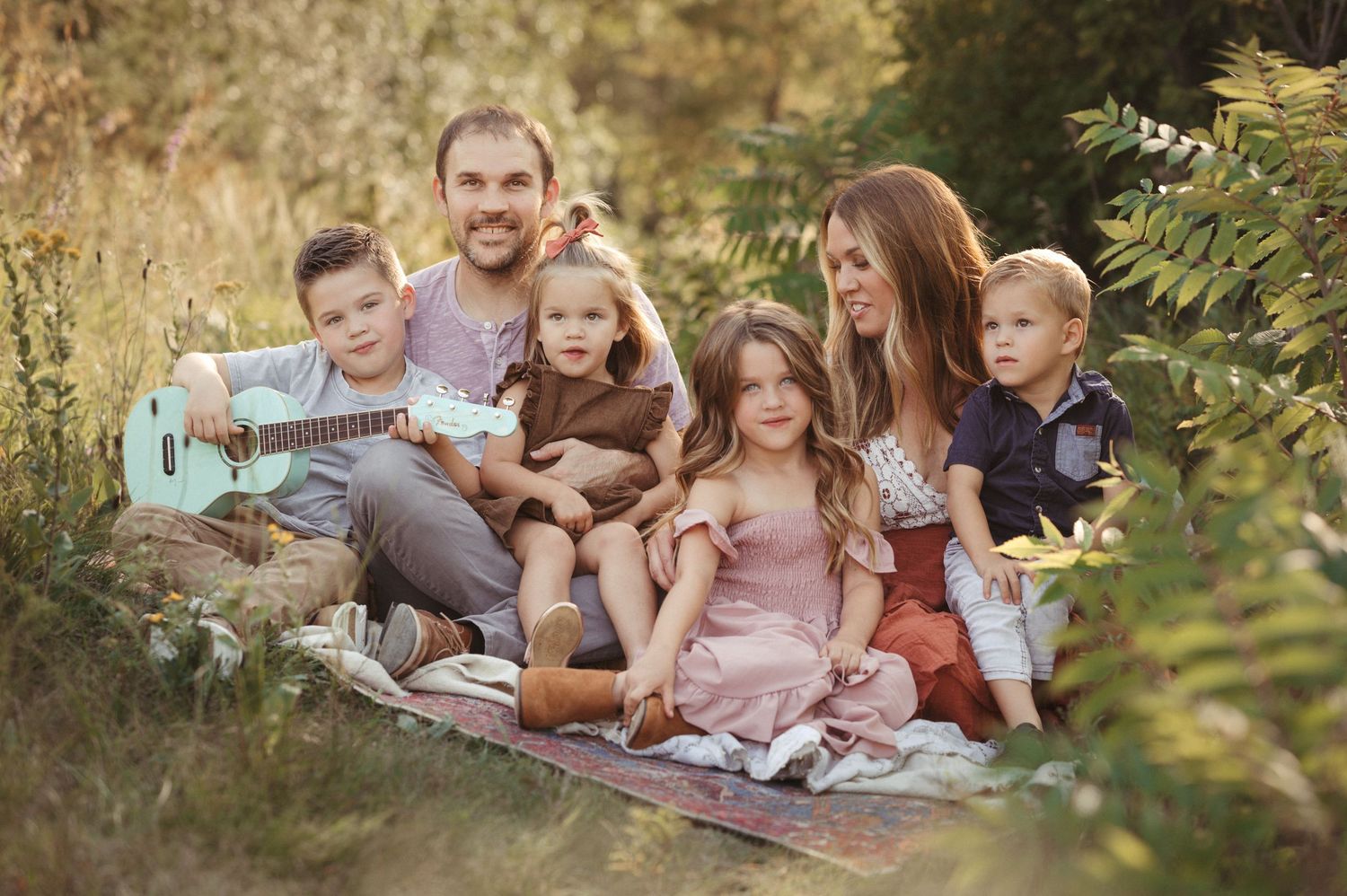 Brookings SD family photographer capturing a loving family outdoors with greenery and warm film-inspired edits.