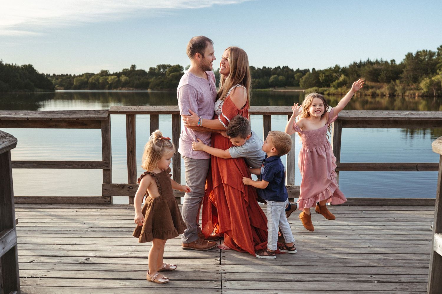 Children playing around their parents during a natural light family session in Sioux Falls.