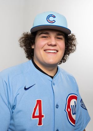 Smiling young baseball player wearing a light blue Chicago Cubs uniform and cap poses for a headshot photo.