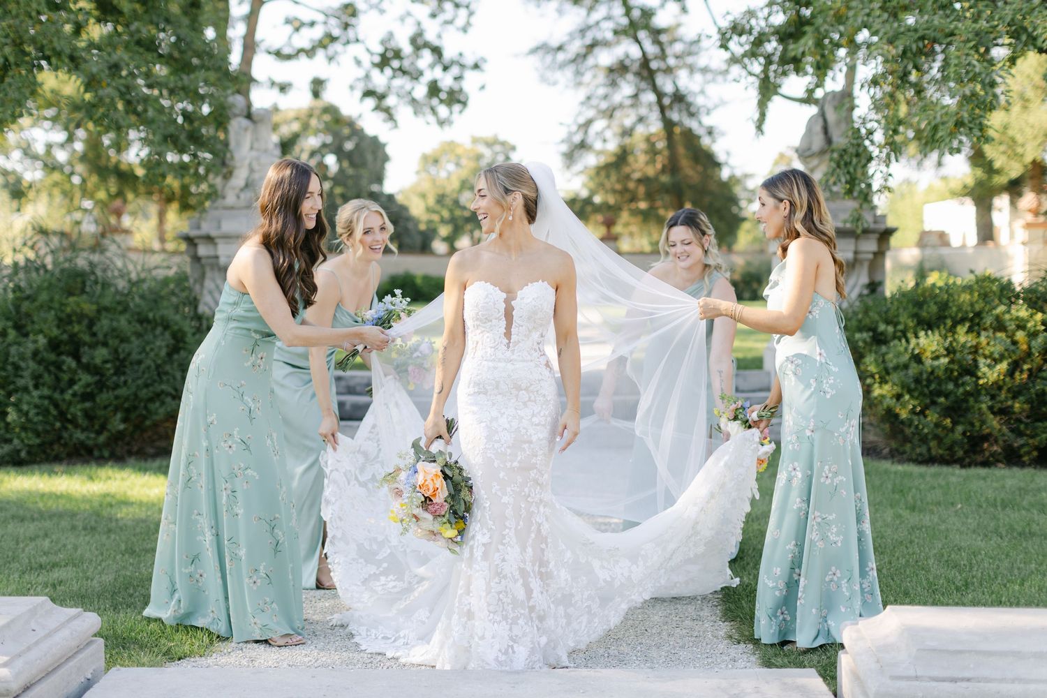 The Armour House Wedding - Bride in white lace gown poses with four bridesmaids in sage green dresses.