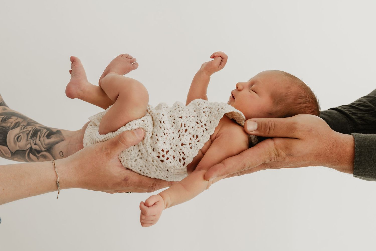 Neugeborenes Baby wird von Mama und Papa gemeinsam gehalten beim Babyfotoshooting Wien Stockerau