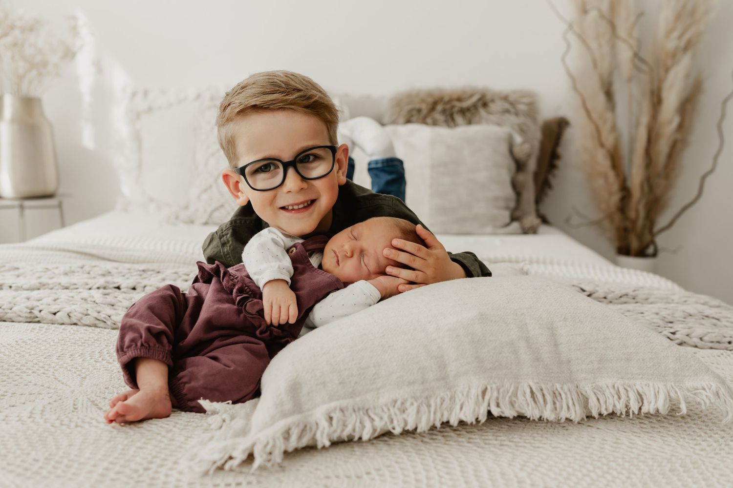 natürliches Geschwisterfoto beim Newbornshooting Stockerau im Fotoatelier auf dem Shooting-Bett