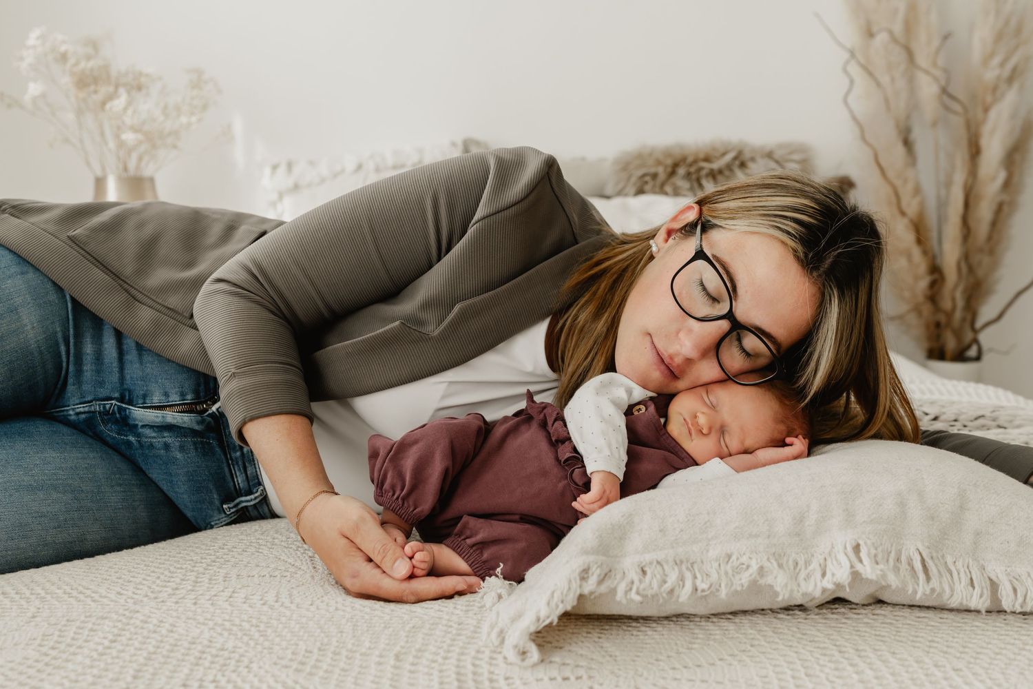 Mama kuschelt mit neugeborenem Baby beim Newbornfotoshooting in Stockerau im Fotostudio