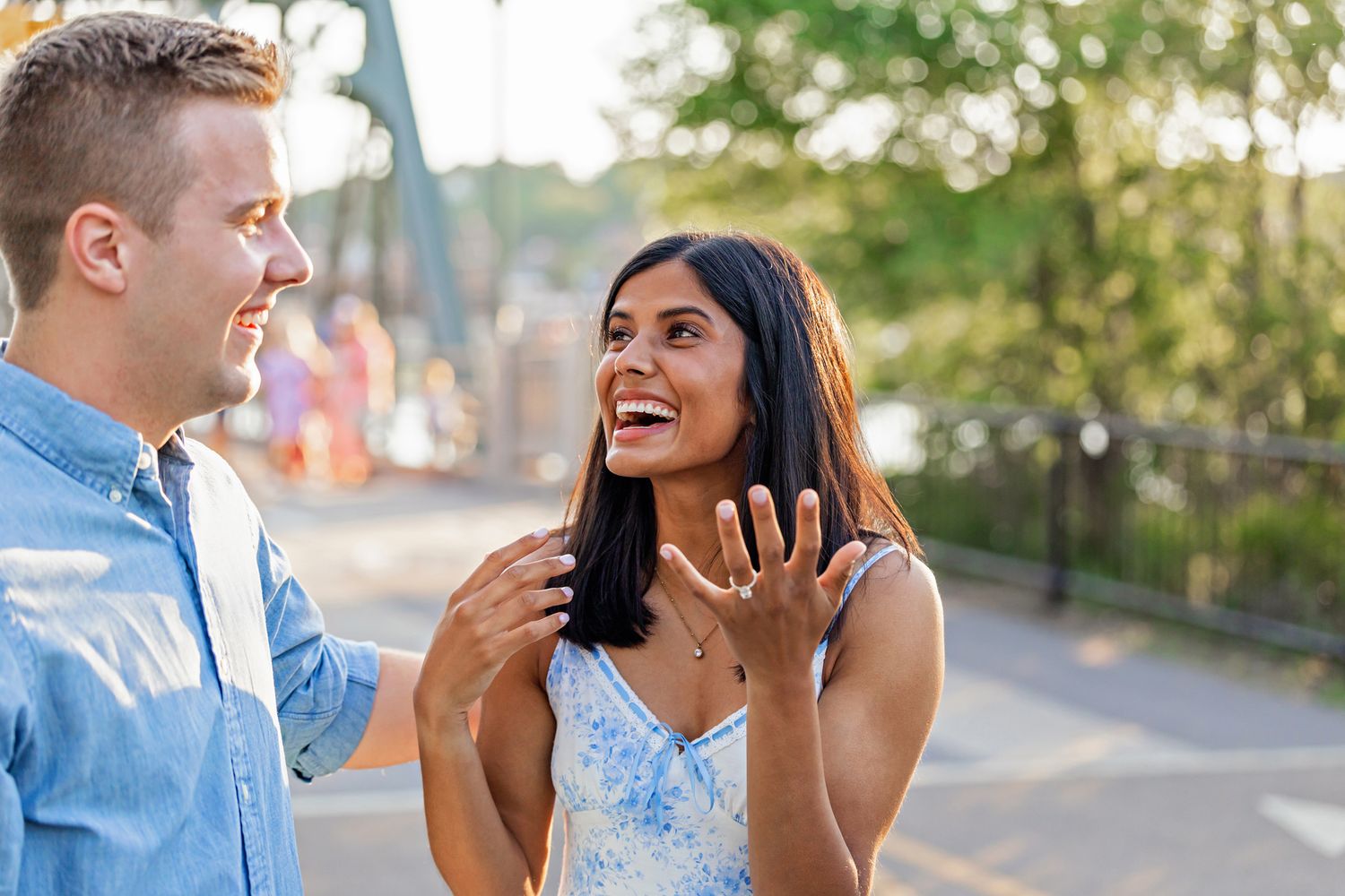 Excited woman shows off her new engagement ring while smiling at her partner. Stillwater, MN.  Proposal Photography by Laura Leigh Images.