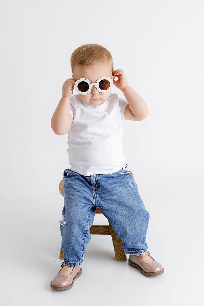 Stylish baby in white tee, jeans, and round sunglasses by Temecula child photographer.