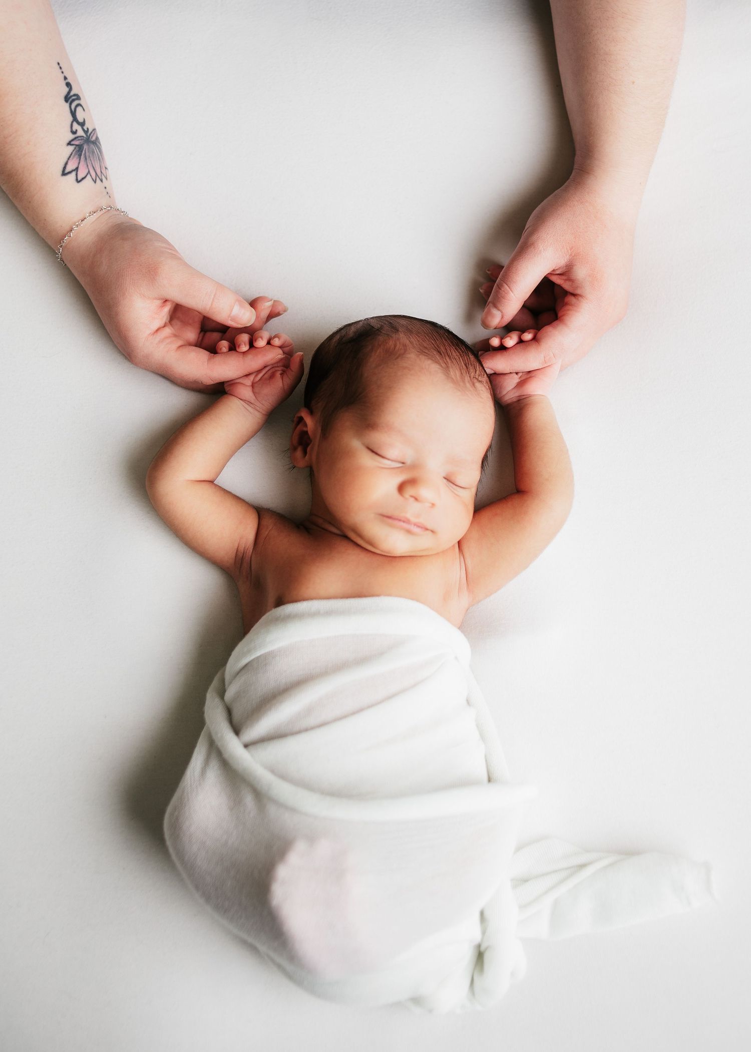 sleeping newborn holding moms hands