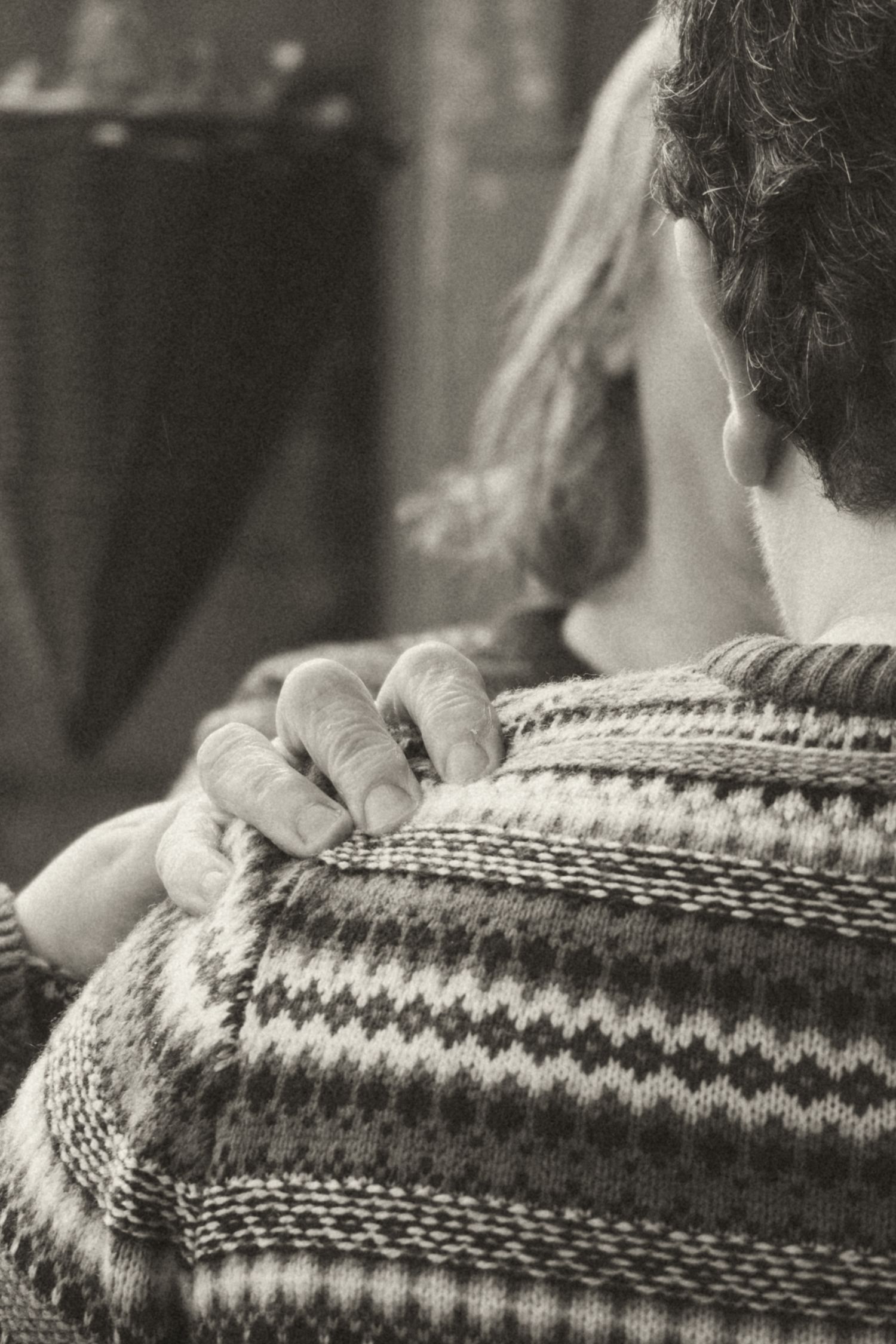 emotive black and white detail shot of a hand on a shoulder during an intimate Scottish wedding