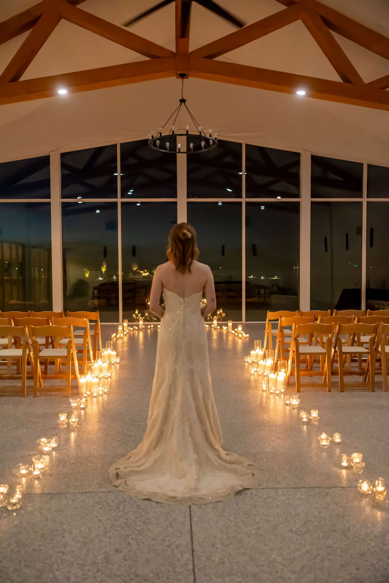 Bride standing in candlelit room camera from behind Milestones Studios LLC at Magnolia Reserve