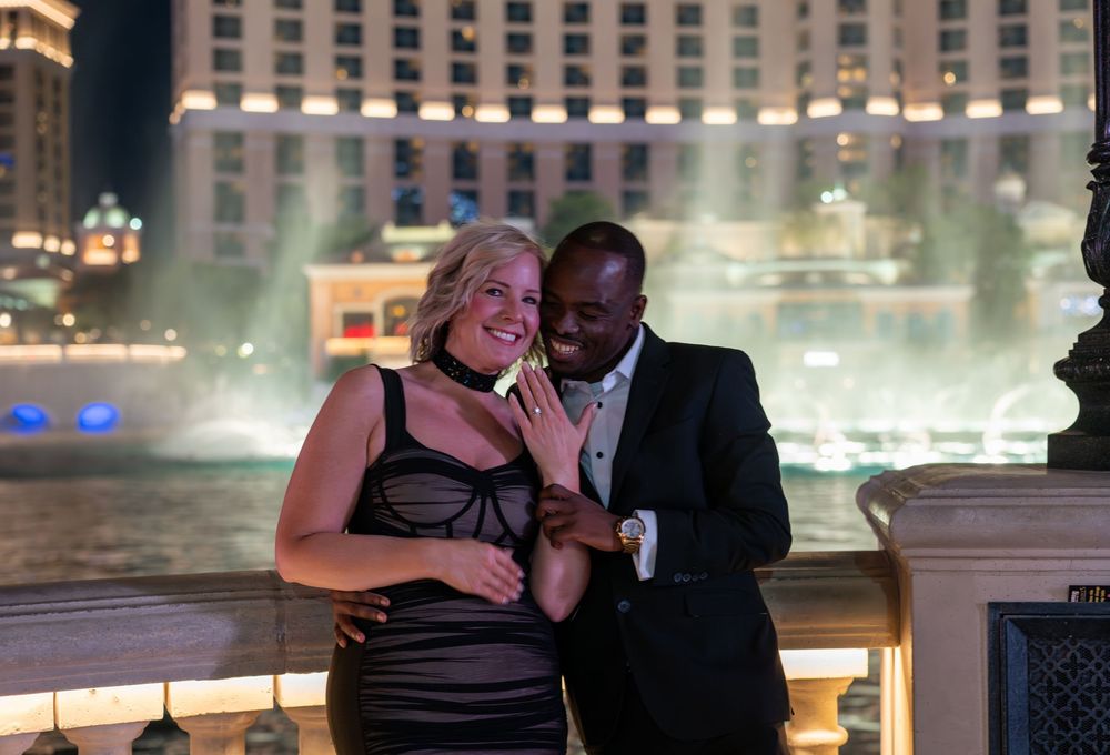 Couple posing romantically in front of the Bellagio fountains at night in Las Vegas.
