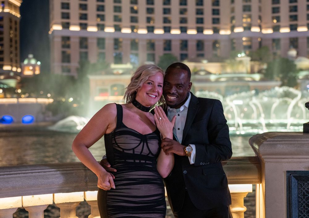 Couple smiling together at night near the Bellagio fountains in Las Vegas.