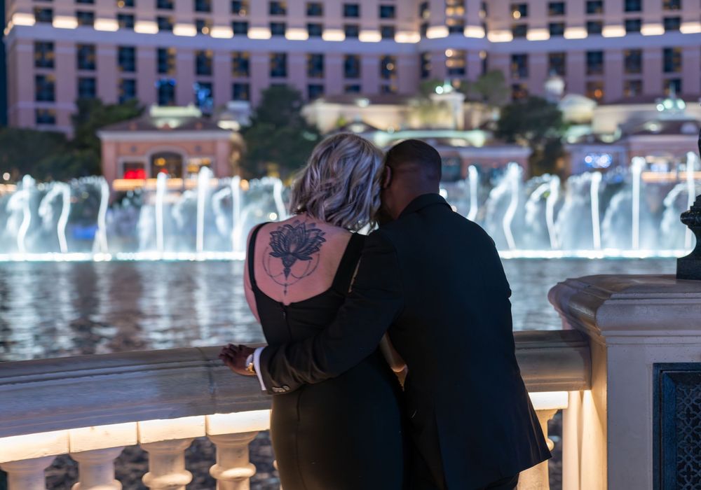 Couple embracing while watching the Bellagio fountain show in Las Vegas at night.