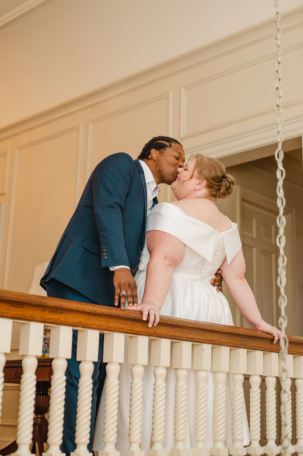 A romantic sequence shows a couple in wedding attire sharing a kiss while leaning over an ornate white staircase banister.