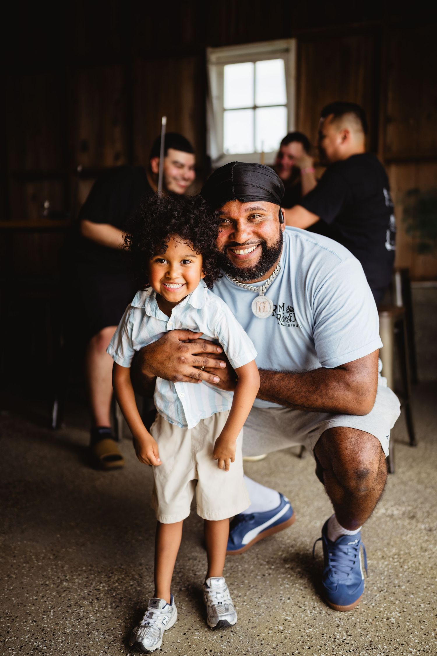 A heartwarming indoor portrait showing genuine joy and connection between two people in casual attire.