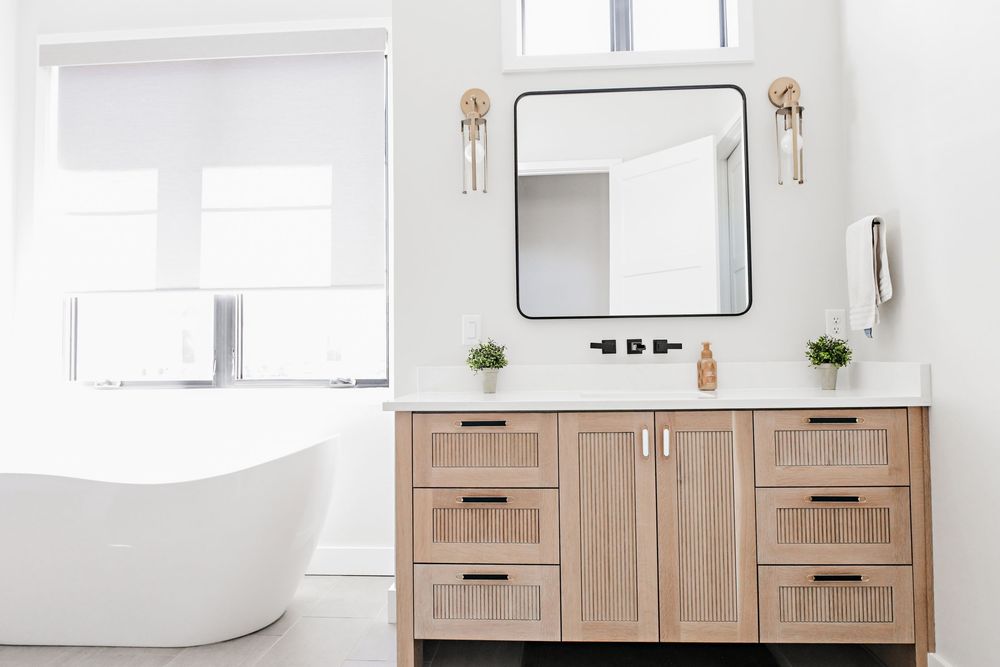 Luxurious bathroom featuring wooden vanity cabinets and elegant wall sconces.