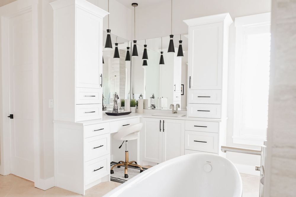 Clean white kitchen space with pendant lighting and modern black accents.