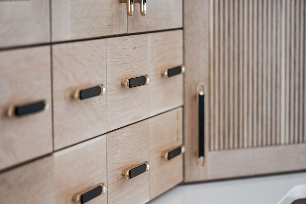 Close-up of textured wood paneling with modern black hardware pulls.